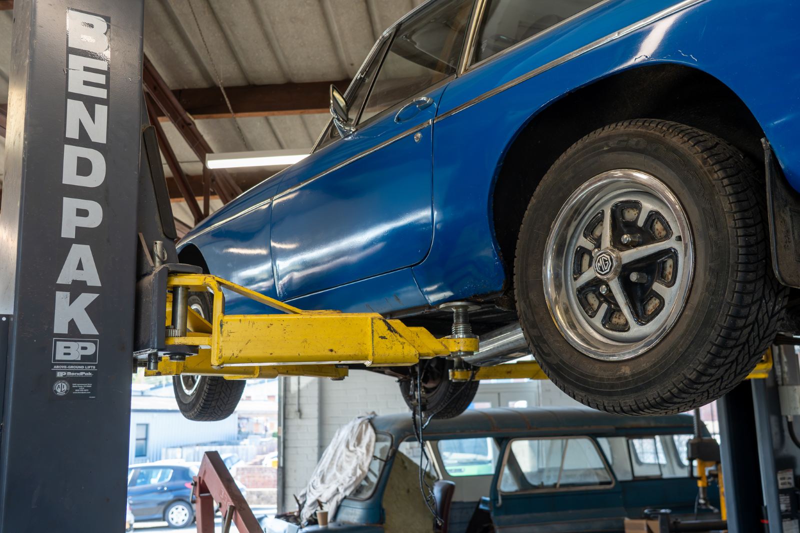 The rear wheel of a classic MG up on the lift