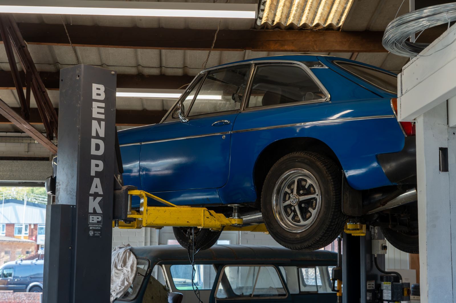 A classic MG up on the lift in the workshop